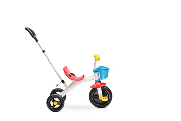 Studio shot of a tricycle for toddlers with a pushing handle