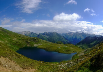 Fototapeta na wymiar gorgeous blue mountain lake in green hills with little ponds panorama