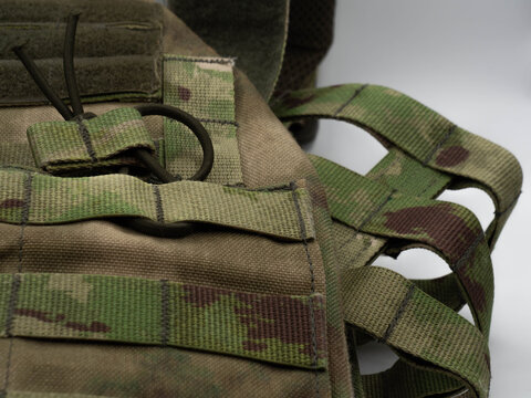 Lightweight camouflage body armor made of textured material close-up. Army, police, airsoft or sports plate carrier with a molle system and Velcro patches.