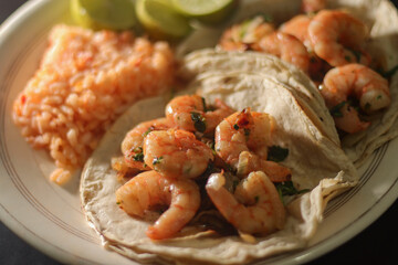 Agillo shrimp tacos with red rice soup and lemons.