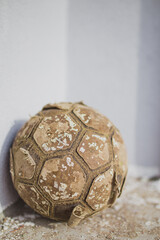 Old torn leather soccer ball at the doorstep - vintage outfit