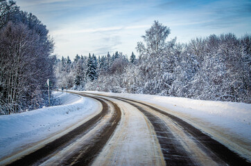 Winter road surrounded by a snowy winter forest in the Moscow region. The nature of Russia.