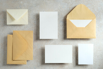 Wedding cards mockup and envelopes on stone table. Top view, flat lay.