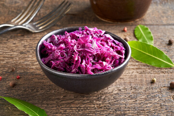 Obraz na płótnie Canvas Fermented red cabbage in a bowl on a table