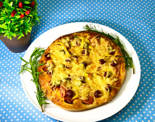 Pizza on a blue background. Homemade pizza on a white plate. Baked dough with cheese.