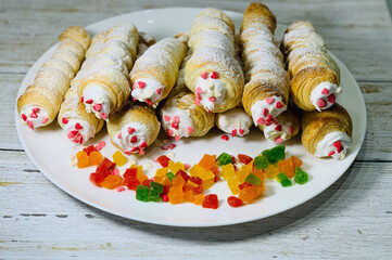 Puff pastry with colorful candied fruits. Sweet puffs of puff pastry with cream. Holiday dessert.