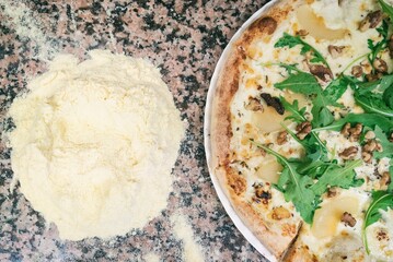Pizza from the oven. Oven-baked pizza with pear and nuts close up