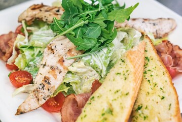 Caesar salad a green salad of romaine lettuce and croutons dressed with lemon juice olive oil, parmesan cheese and chicken. Also called Cesare salad