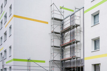 renovation of the facade of an apartment house using scaffolding - obrazy, fototapety, plakaty