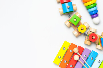 Children's toys made of natural wood on white background. Multi-colored pyramid, train, xylophone in rainbow colors. Eco friendly toy, plastic free. Toy for babies and toddlers. Flat lay top view
