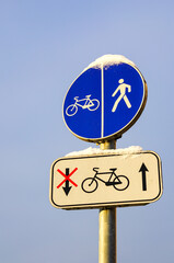 snowy bicycle and pedestrian lane round road sign on pole