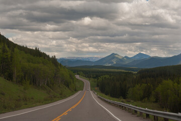 Curving highway following the edge of the Eastern slopes of the Rocky Mountains of Alberta on a moody day