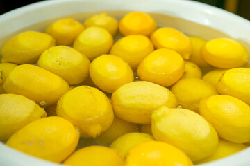 The process of making limoncello lemon liqueur at home. Lemons are prepared for washing in a...
