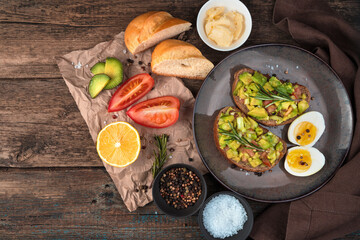 Breakfast with avocado sandwiches on a wooden background. Top view, with space to copy. The concept of proper nutrition.