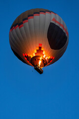Hot air balloon flying over rock landscape at Cappadocia Turkey.