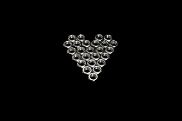 Heart shape made of hex bolts on dark grey background. Creative love concept