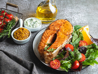 fried roasted fish steak salmon, trout with salad and tomatoes