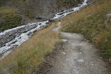 Fototapeta premium Wanderweg hin zu einer Brücke über einen Gebirgsbach