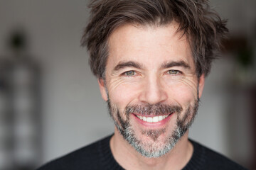 Close-pu Of A Mature Man Smiling And Having Fun. Home inside. lot of hair.