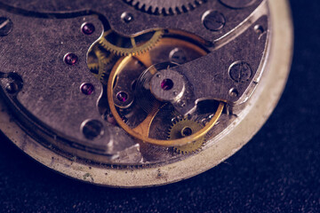 Old clockwork mechanism in close-up. Selective focus on macro details. Light vintage toning. Grunge style backdrop
