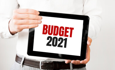 Text budget 2021 on tablet display in businessman hands on the white bakcground. Business concept