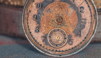 Vintage grunge background of an old clock. Abstract texture covered with dust, dirt, scratches. Macro photography in light tinted
