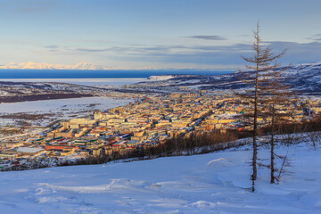 Beautiful winter landscape with the northern city. The city of Magadan is located among the mountains on the coast of the Sea of ​​Okhotsk. Magadan Region, Russia. Russian Far East. Siberia.