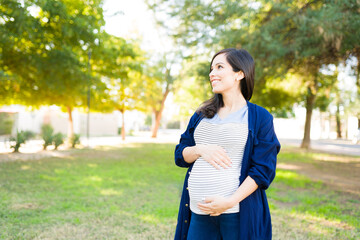 Good-looking pregnant woman stroking her belly