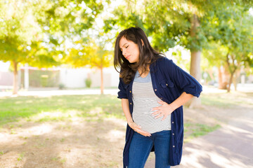 Distressed woman having contractions outdoors