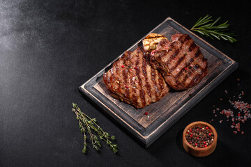 Fresh juicy delicious beef steak on a dark background