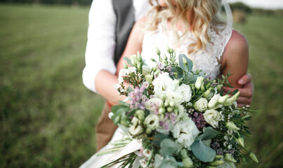 Wedding bouquet in the hands of the bride and groom. 