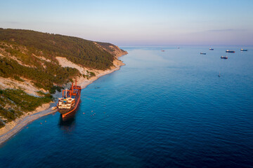Big cargo ship running aground. view from above. Panorama of the sea bay at sunset