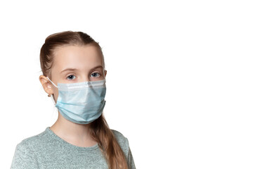 Beautiful young girl with long hear and in the medical mask looks at the camera