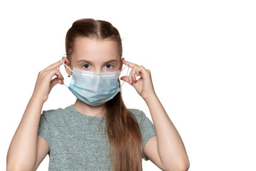 Beautiful young girl puts on medical mask and looks at the camera