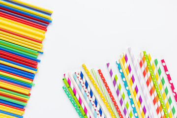 Many colorful plastic and eco friendly paper straws on white background. Recycle, environment...