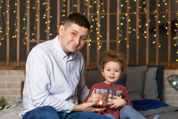 caring dad making a surprise to child. Father giving his smiling daughter a gift box for a holiday at home. father’s day. happy fatherhood, parenting and childhood.