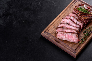 Fresh juicy delicious beef steak on a dark background