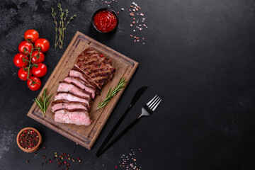 Fresh juicy delicious beef steak on a dark background