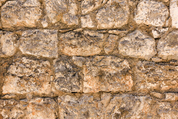 Natural old beige stone wall textured background. Close up. Copy space.