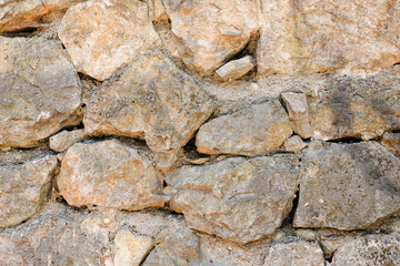 Natural old beige stone wall textured background. Close up. Copy space.