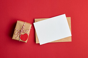 Valentines day card mockup with envelope and gift box with heart on red paper background