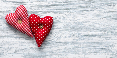 Two fabric hearts on wooden background