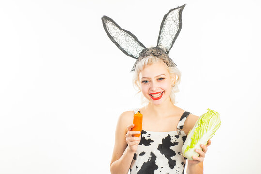 Easter bunny woman with vegetables. Rabbit girl with carrot and cabbage.