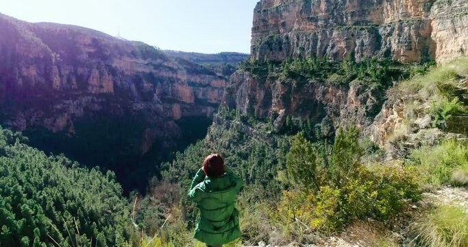 Mujer senior observando por prism&aacute;ticos ca&ntilde;&oacute;n de monta&ntilde;a y dron orbitando