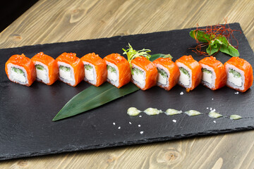 Sushi roll (Philadelphia) with salmon, smoked eel, avocado, cream cheese on black background. Sushi menu. Japanese food.