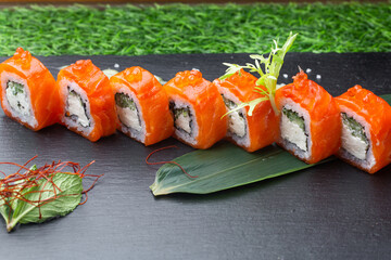 Sushi roll (Philadelphia) with salmon, smoked eel, avocado, cream cheese on black background. Sushi menu. Japanese food.