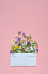 bouquet of flowers on pink paper background.copy space.top view