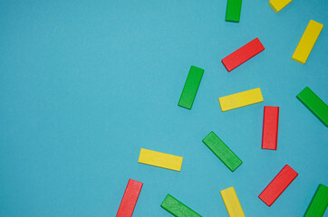 Scattered Pile of Toy Colored Wooden Bricks on blue background free space to insert