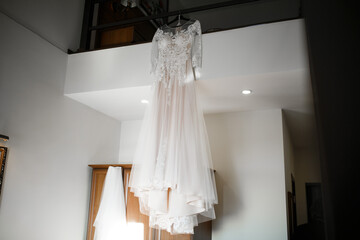 Fototapeta na wymiar The wedding dress is hanging in the house. Wedding morning.