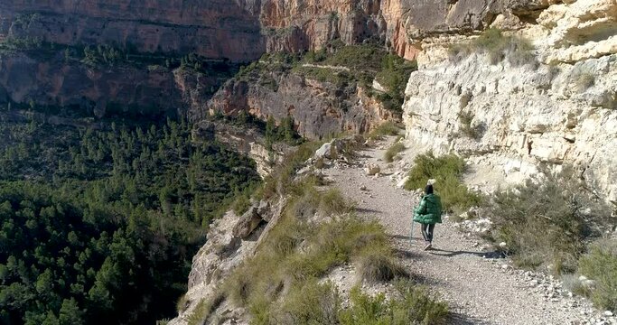 vista cenital dron de senderista mujer senior caminando por barranco alta monta&ntilde;a
